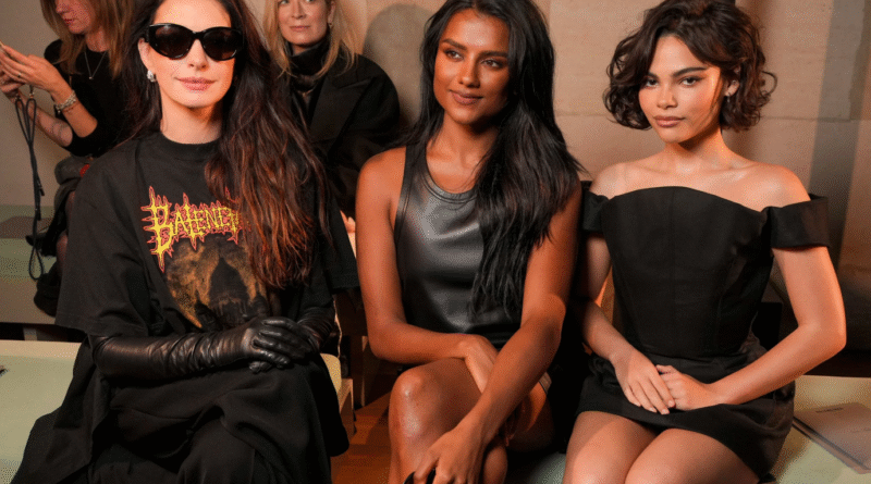 Anne Hathaway showcases t-shirt train fashion while seated front row at Balenciaga’s Paris Fashion Week show with Simone Ashley and Ariana Greenblatt.