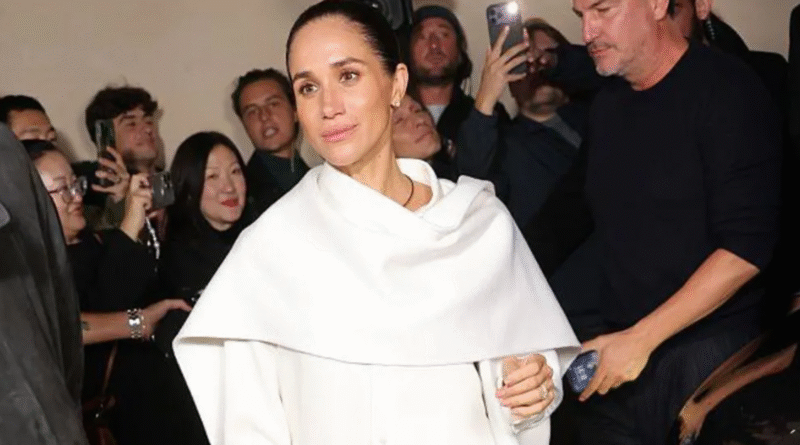 Meghan Balenciaga appearance at Paris Fashion Week wearing a white Balenciaga ensemble with a shawl collar, attending the show in elegant style.